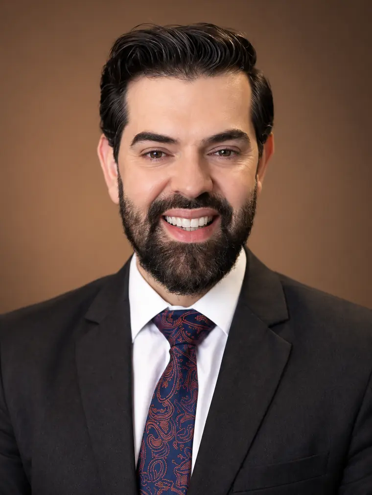 Leandro Jesuíno da Silva, advogado, de terno escuro e gravata, sorrindo